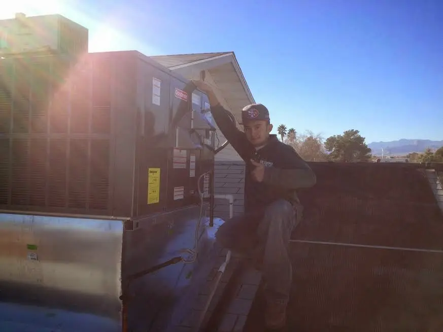 HVAC technician performing AC Tune-Up on a rooftop unit in Takoma Park